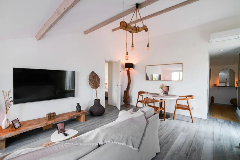 Séjour de la suite Helios à Saint-Cyr-sur-Mer, avec canapé, télévision et cuisine ouverte équipée.