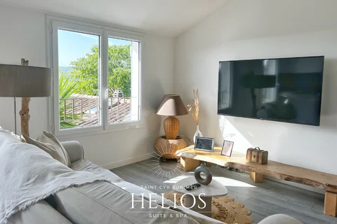 Le séjour de la suite Helios avec son canapé, sa télévision et son coin repas à Saint-Cyr-sur-Mer.